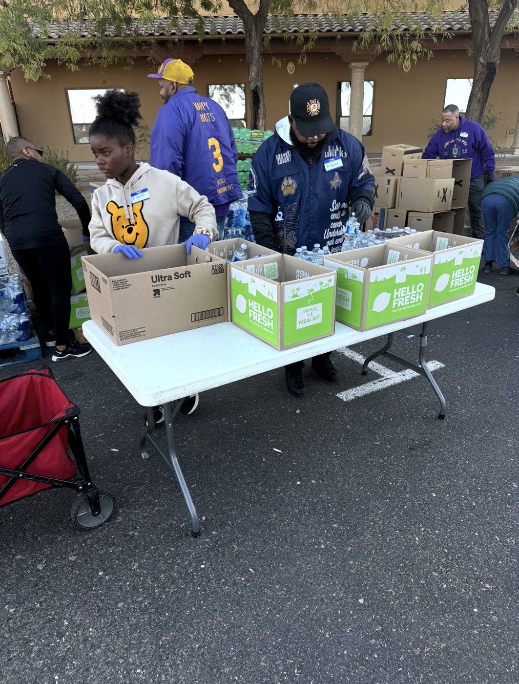 Volunteers packing meal kits and water at a distribution event